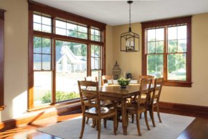 Dining room with wood floors, dining table, and wood-frame windows.