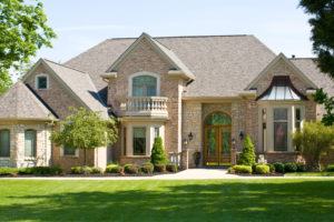 An Expensive Home with white vinyl windows against a Blue Sky