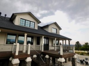 Large home with expansive wood windows. Gray skies in background.