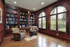 Study room with specialty shaped wood windows overlooking yard.